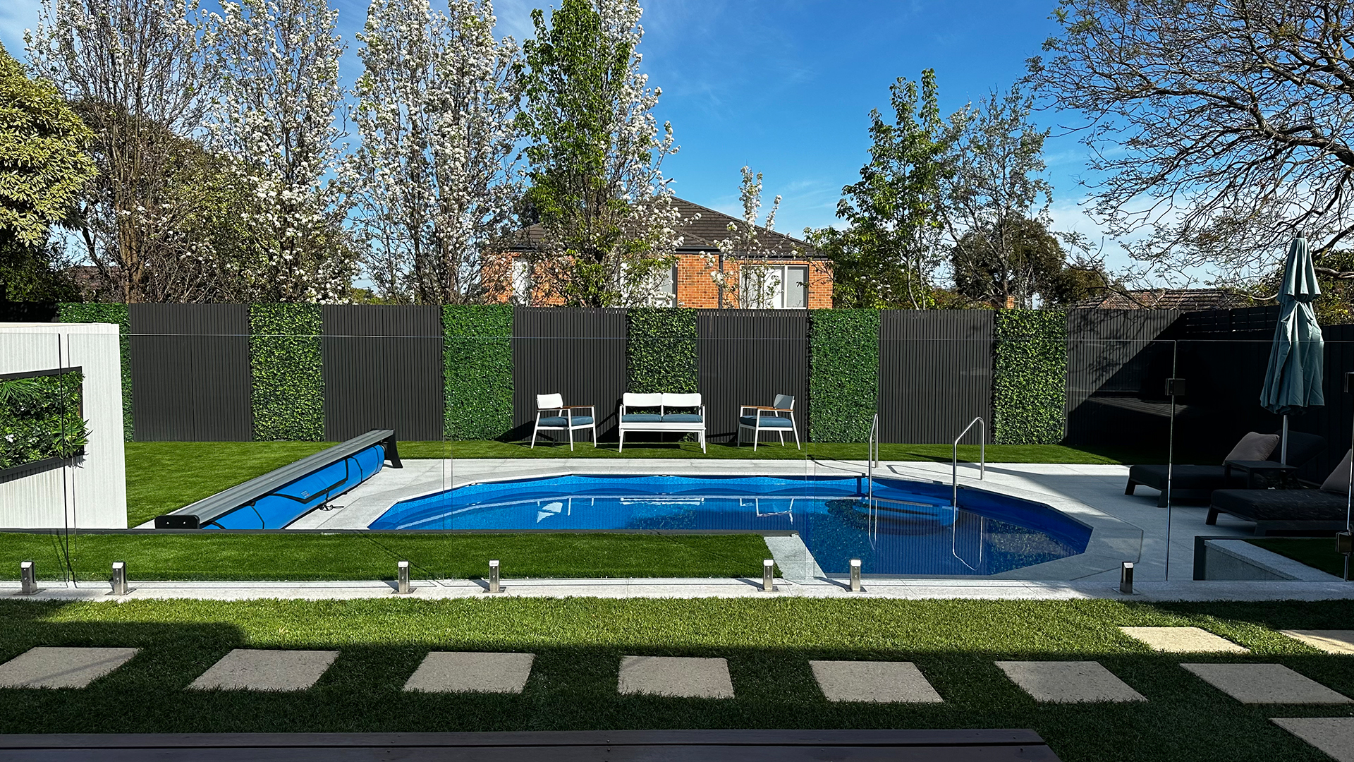 Finished Poolsabove backyard pool surrounded by established trees